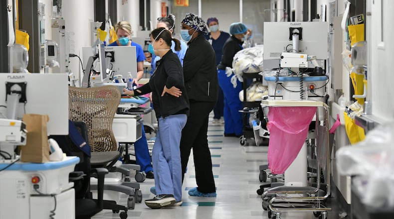 Health workers work on mobile medical units in the hallway of the temporary COVID-19 ICU at Northeast Georgia Medical Center (NGMC) in Gainesville on Wednesday, Jan. 20, 2021, during a particularly deadly period of the COVID-19 battle. (Hyosub Shin / Hyosub.Shin@ajc.com)