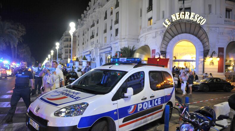 A police car is parked near the scene of an attack after a truck drove onto the sidewalk and plowed through a crowd of revelers who'd gathered to watch the fireworks. Five years ago in France, a man drove a truck through crowds celebrating Bastille Day along Nice’s beachfront, killing 86 and wounding more than 100. (AP Photo/Christian Alminana)