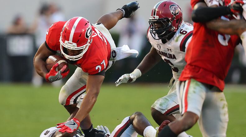 Georgia tailback Nick Chubb goes over South Carolina defender Skai Moore for extra yardage in the second half on the way to a 24-10 victory and a 9-0 record in a NCAA college football game on Saturday, November 4, 2017, in Athens. Curtis Compton/ccompton@ajc.com