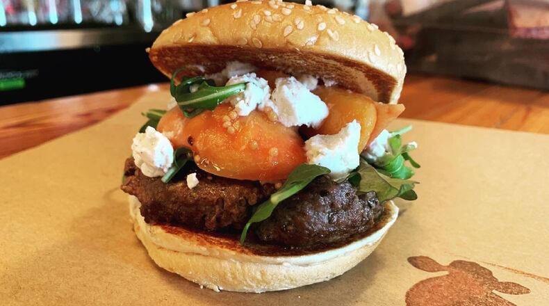 The seasonal peach burger at Farm Burger features peaches and goat cheese from local farms. Courtesy of Farm Burger
