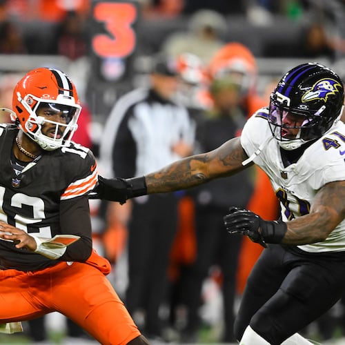 Cleveland Browns quarterback Shedeur Sanders (12) is pressured out of the pocket by Baltimore Ravens' Dre'Mont Jones (41) in the second half of an NFL football game in Cleveland, Sunday, Nov. 16, 2025. (AP Photo/David Richard)
