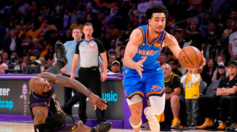 Oklahoma City Thunder guard Jared McCain, right, drives toward the basket as Los Angeles Lakers forward LeBron James falls during the second half of Game 4 in a second-round NBA basketball playoffs series Monday, May 11, 2026, in Los Angeles. (AP Photo/Mark J. Terrill)