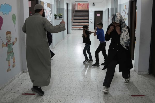 Students and teachers react to tear gas fired by Israeli Police into in the yard of the UNRWA Boys' School run by the U.N. agency for Palestinian refugees in the Shuafat Refugee Camp in east Jerusalem, Tuesday, April 29, 2025.(AP Photo/Mahmoud Illean)