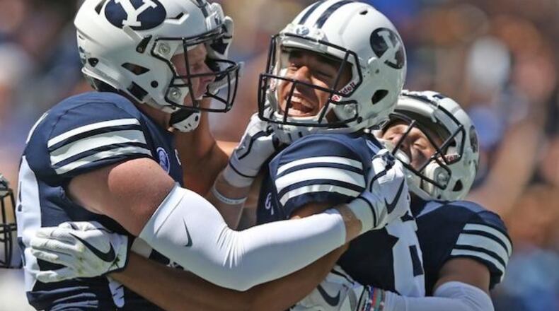 BYU wide receiver Neil Pau'u, center, celebrates his touchdown with teammates Matt Bushman, left, and Inoke Lotulelei, right, in the first half of an NCAA college football game against Portland State, Saturday, Aug. 26, 2017, in Provo, Utah. (AP Photo/Rick Bowmer)