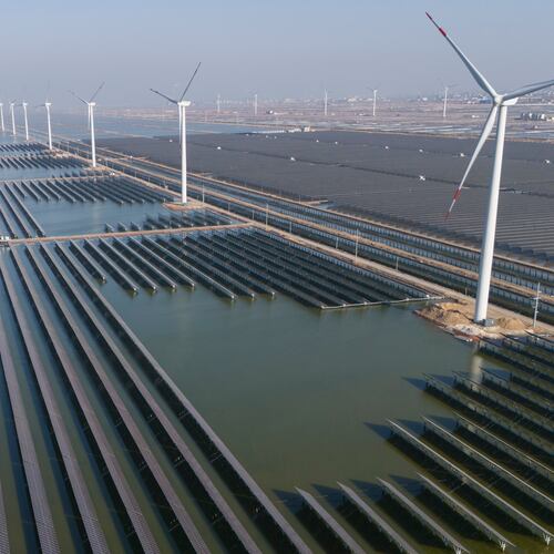 FILE - Wind turbines operate along a solar farm near Weifang in eastern China's Shandong province on March 22, 2024. (AP Photo/Ng Han Guan, File)