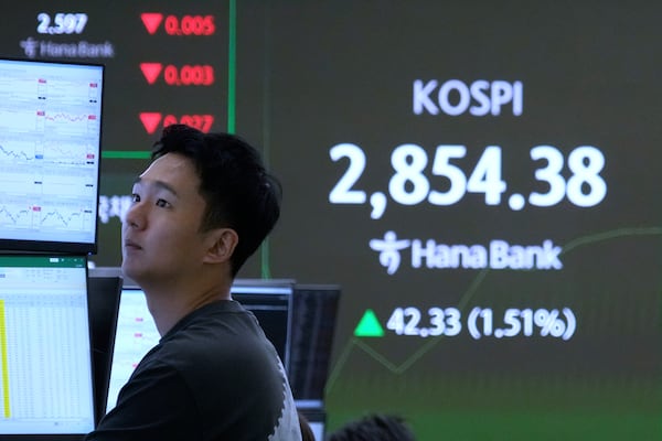 A currency trader watches monitors near a screen showing the Korea Composite Stock Price Index (KOSPI) at the foreign exchange dealing room of the KEB Hana Bank headquarters in Seoul, South Korea, Monday, June 9, 2025. (AP Photo/Ahn Young-joon)