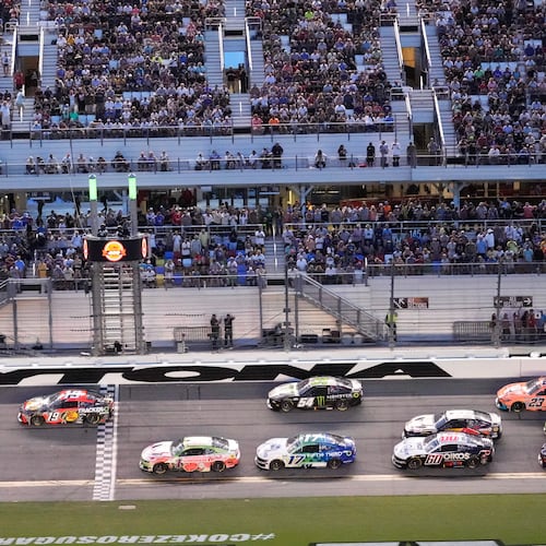 Kyle Larson (5) and Chase Briscoe (19) lead a group through the front stretch during early laps in the NASCAR auto race at Daytona International Speedway, Saturday, Aug. 29, 2026, in Daytona Beach, Fla. (AP Photo/John Raoux)