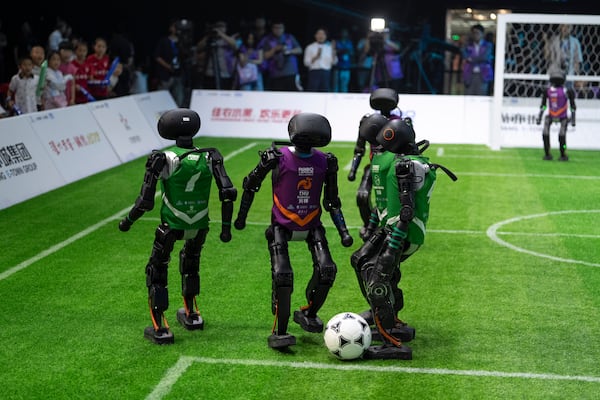 Teams using autonomous T1 robots from Booster Robotics compete in the inaugural RoBoLeague robot soccer competition held in Beijing, Saturday, June 28, 2025. (AP Photo/Ng Han Guan)