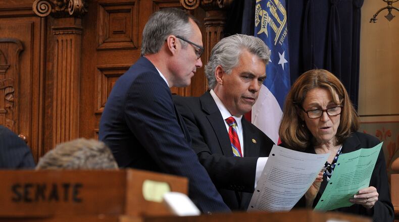 Lt. Gov. Casey Cagle, left, Sen. Judson Hill and Irene Munn, general counsel and director of policy with the lieutenant governor's office, look over changes made in the House to Hill's bill, SB 98. The bill would bar the state employee health insurance plan from covering abortions in most cases. BRANT SANDERLIN /BSANDERLIN@AJC.COM