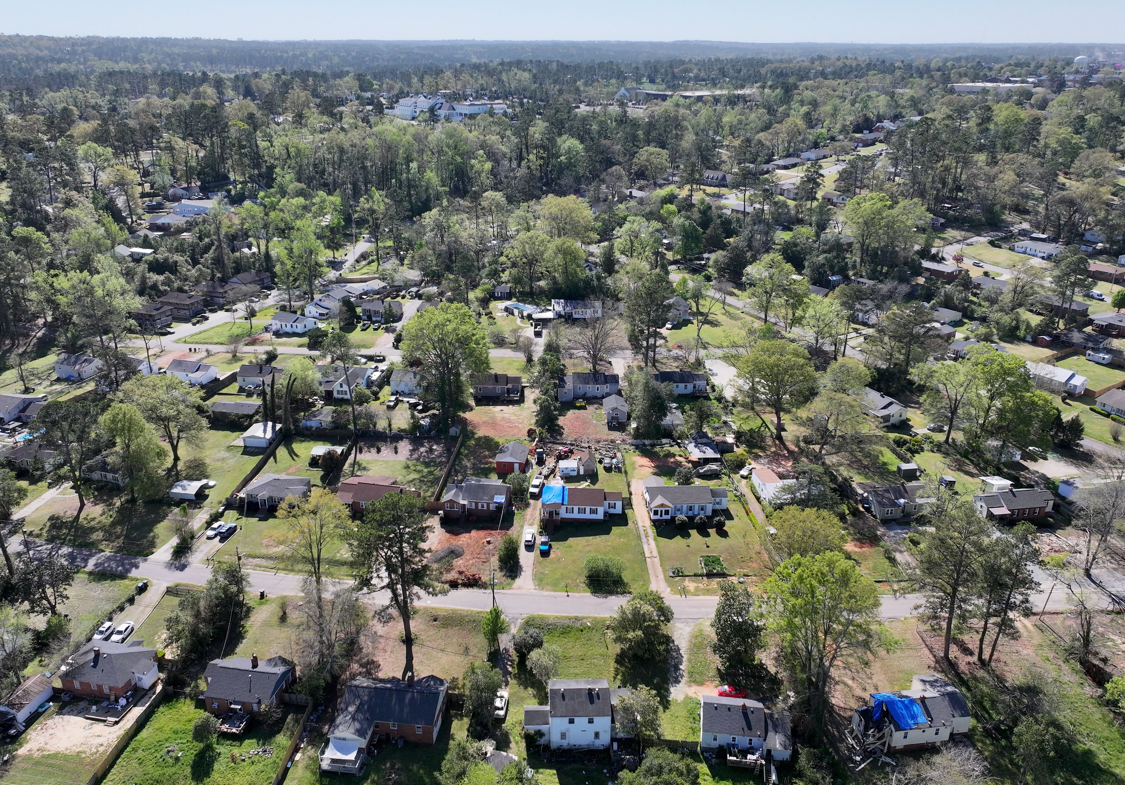 Aerial photo shows neighborhoods near Augusta National Golf Club (background), six months after Hurricane Helene landed. Some of the storm’s worst impacts were in Augusta, far from where it came on shore. (Hyosub Shin/AJC)