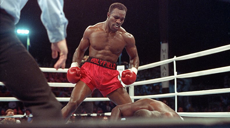 Evander Holyfield strikes the pose of a champion over the fallen Buster Douglas. (AP Photo/Douglas C. Pizac)