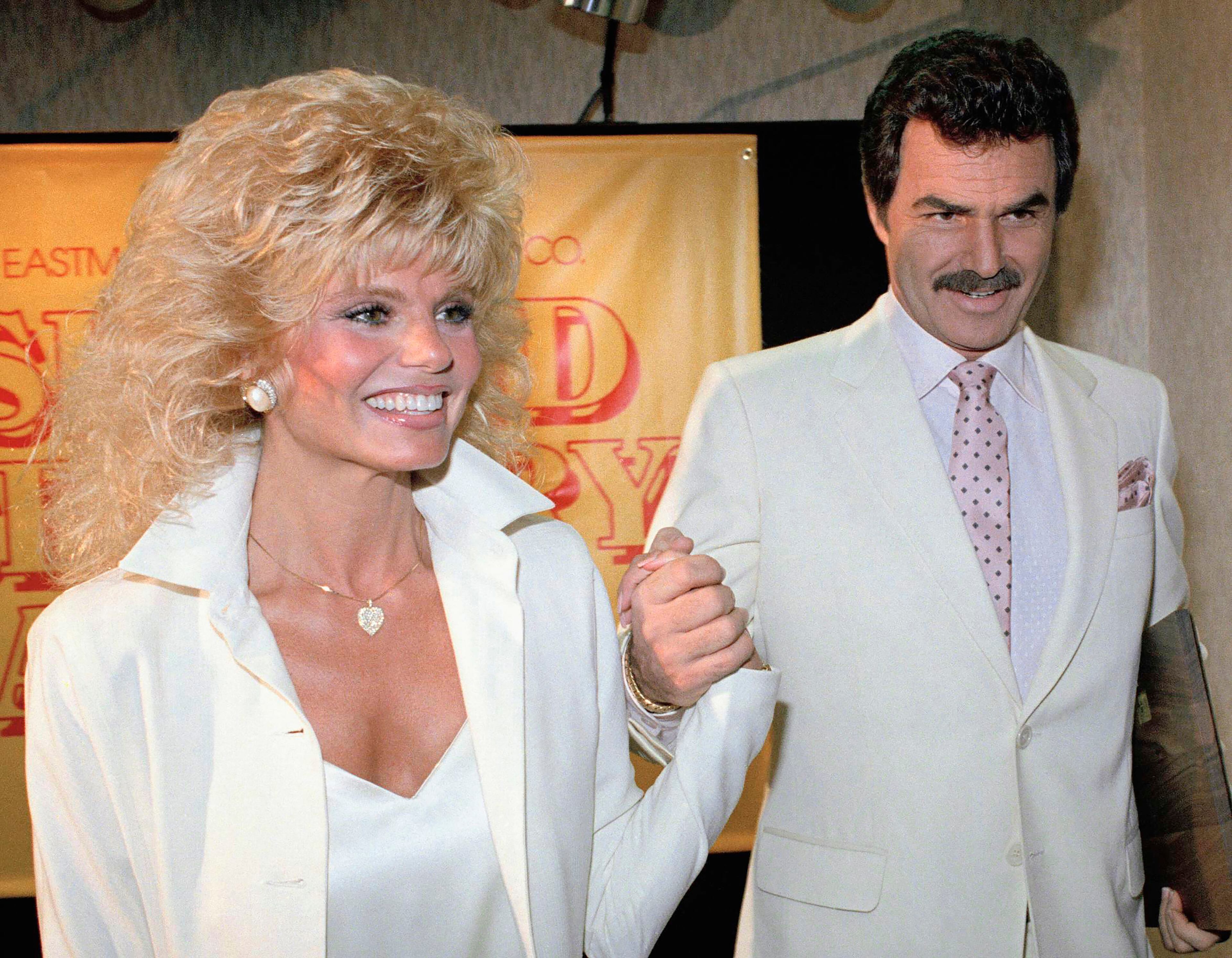 Loni Anderson holds hands with Burt Reynolds at a luncheon in Los Angeles. (Bob Galbraith/AP/1987)