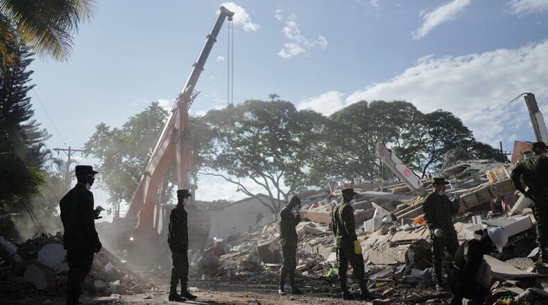 Soldiers clear debris three days after an earthquake struck Cali, Colombia, Thursday, Aug. 13, 2026. (AP Photo/Ivan Valencia)
