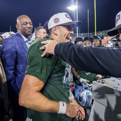Tulane head coach Jon Sumrall, right, reacts with Tulane quarterback Jake Retzlaff (12) after winning the American Conference championship NCAA college football game against North Texas in New Orleans, Friday, Dec. 5, 2025. (AP Photo/Matthew Hinton)