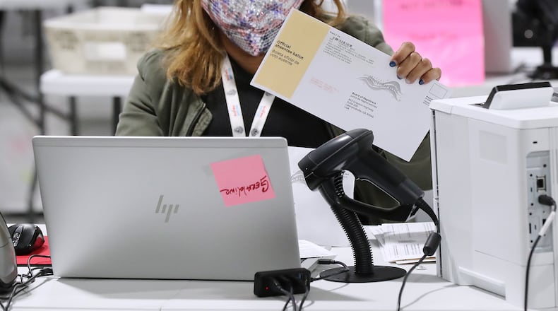 An election worker checks in, sorts and verifies signatures on absentee ballots at the Beauty P. Baldwin Voter Registrations and Elections Office on Tuesday night, Jan. 5, 2021, in Lawrenceville. Curtis Compton / Curtis.Compton@ajc.com”