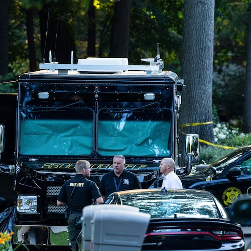 Law enforcement officials gather to investigate a fatal house fire on Friday, July 24, 2026, in Grand Haven Township, Mich. Ottawa County Sheriff's Office said six children and two adults were found dead in a "suspicious" house fire. (Joel Bissell/Kalamazoo Gazette via AP)