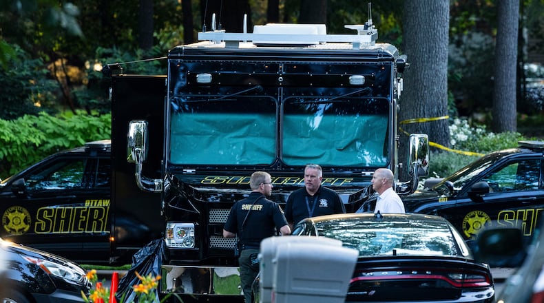 Law enforcement officials gather to investigate a fatal house fire on Friday, July 24, 2026, in Grand Haven Township, Mich. Ottawa County Sheriff's Office said six children and two adults were found dead in a "suspicious" house fire. (Joel Bissell/Kalamazoo Gazette via AP)