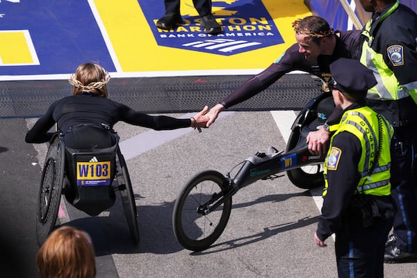 Marcel Hug, of Switzerland, right, congratulates Susannah Scaroni, of the United States, after winning the men's and women's wheelchair divisions during the Boston Marathon, Monday, April 21, 2025, in Boston. (AP Photo/Charles Krupa)