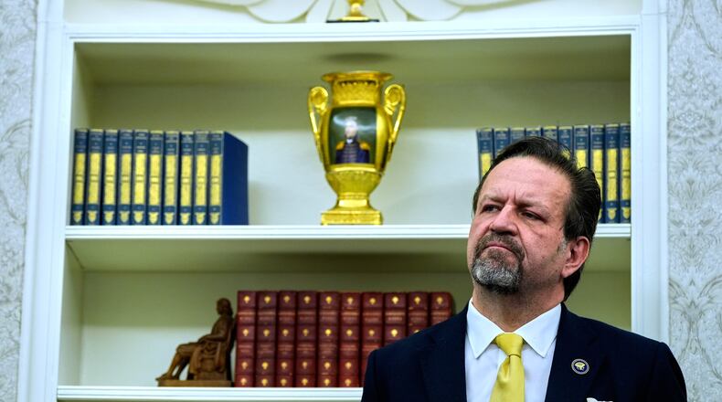 FILE - Sebastian Gorka listens as President Donald Trump speaks with reporters after signing executive orders in the Oval Office of the White House, April 23, 2025, in Washington. (AP Photo/Alex Brandon, File)