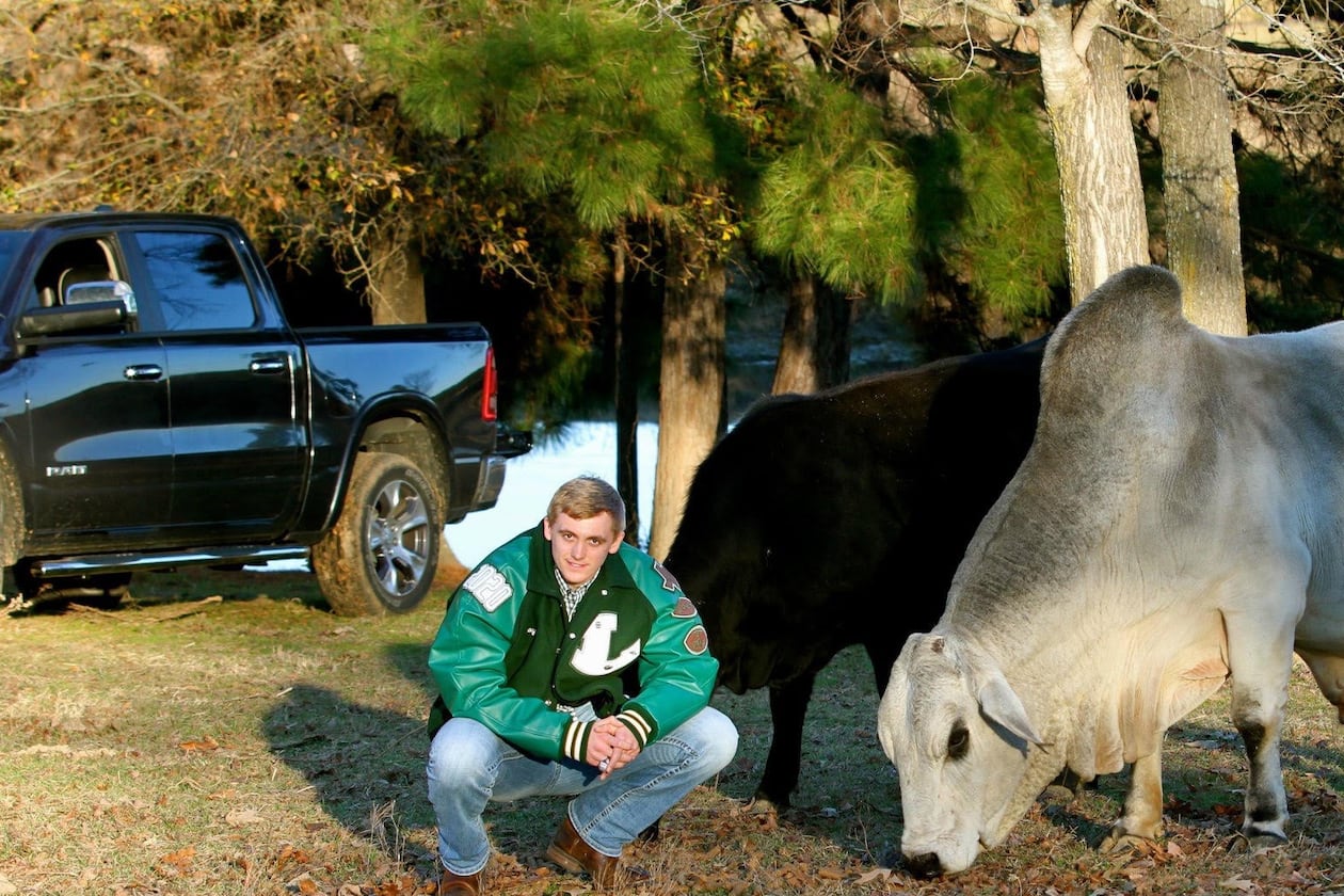 Georgia Tech quarterback Haynes King poses with his father's bull Gunsmoke on the family's 12-acre farm. King grew up tending to the family's cattle. As John King told it, the black cow in the background was not supposed to be in the photo but wouldn't get out of the frame. (Courtesy of John King)