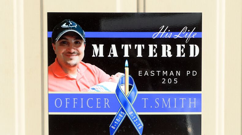 A memorial poster is on the door of the Eastman Police Department. Officer Tim Smith was not wearing his bulletproof vest and the department is now reviewing whether it should have a policy regarding body armor. KENT D. JOHNSON/KDJOHNSON@AJC.COM
