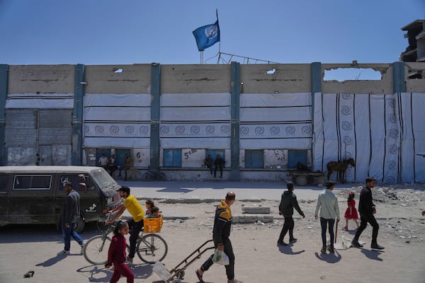 FILE - Palestinians walk next to the closed humanitarian aid distribution center of UNRWA, the U.N. agency helping Palestinian refugees in Jabaliya, Gaza Strip on Tuesday, April 29, 2025. (AP Photo/Jehad Alshrafi, File)