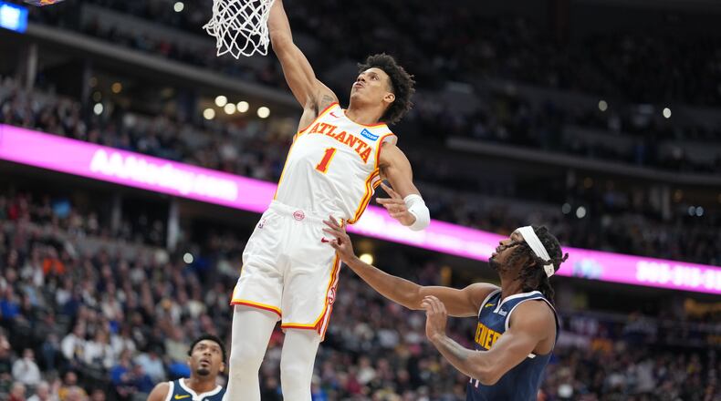 Atlanta Hawks forward Jalen Johnson, left, goes up for a basket as Denver Nuggets center DaRon Holmes defends in the first half of an NBA basketball game Friday, Jan. 9, 2026, in Denver. (AP Photo/David Zalubowski)