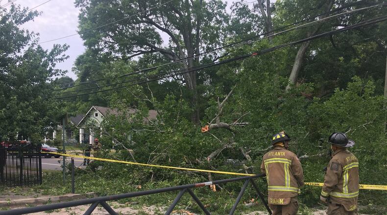 A large tree and power lines fell on a vehicle in southwest Atlanta, trapping its driver.