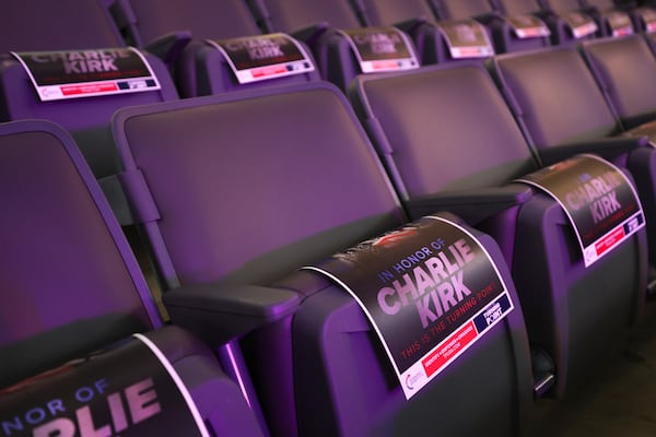 Flyers featuring the late Charlie Kirk appear on empty seats at a Turning Point USA event at Akins Ford Arena in Athens on Tuesday. (Arvin Temkar/AJC)