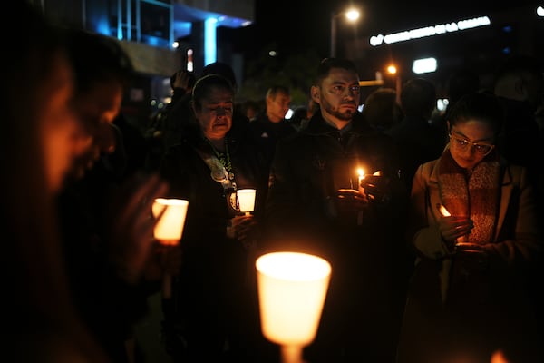 People hold candles during a vigil outside the Santa Fe hospital where Colombian senator and presidential candidate Miguel Uribe Turbay is being treated after he was shot during a campaign rally in Bogota, Colombia, Saturday, June 7, 2025. (AP Photo/Ivan Valencia)