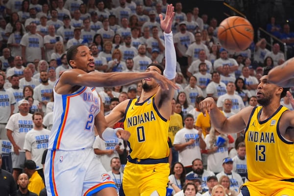 Oklahoma City Thunder guard Shai Gilgeous-Alexander (2) dishes off as Indiana Pacers guard Tyrese Haliburton (0) defends during the first half of Game 5 of the NBA Finals basketball series, Monday, June 16, 2025, in Oklahoma City. (AP Photo/Kyle Phillips)
