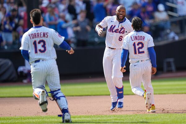 New York Mets' Starling Marte, center, celebrates with teammates after hitting a walk-off single during the tenth inning of a baseball game against the Philadelphia Phillies, Wednesday, April 23, 2025, in New York. (AP Photo/Seth Wenig)