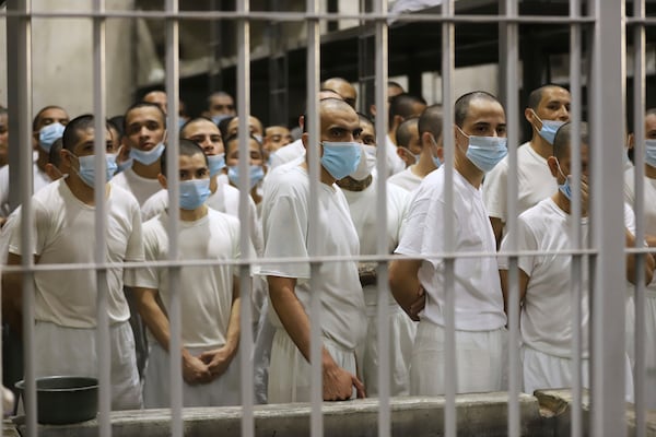 Prisoners look from their cell as the Costa Rica Justice and Peace minister tours the Terrorist Confinement Center in Tecoluca, El Salvador, Friday, April 4, 2025. (AP Photo/Salvador Melendez)