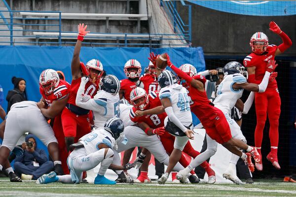 The Class 3A football championship last month spurred the debate over using instant replay to review officials’ calls. Sandy Creek (in red) beat Cedar Grove (in white) 21-17 after scoring the winning touchdown on a third-down run that GPB Sports replays showed was stopped short of the goal line. In the photo above, a kick is blocked. (Jason Getz/The Atlanta Journal-Constitution)