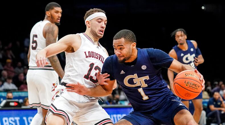 Georgia Tech's Kyle Sturdivant (1) drives against Louisville's Jarrod West (13) during the first half of an NCAA college basketball game of the Atlantic Coast Conference men's tournament, Tuesday, March 8, 2022, in New York. (AP Photo/John Minchillo)