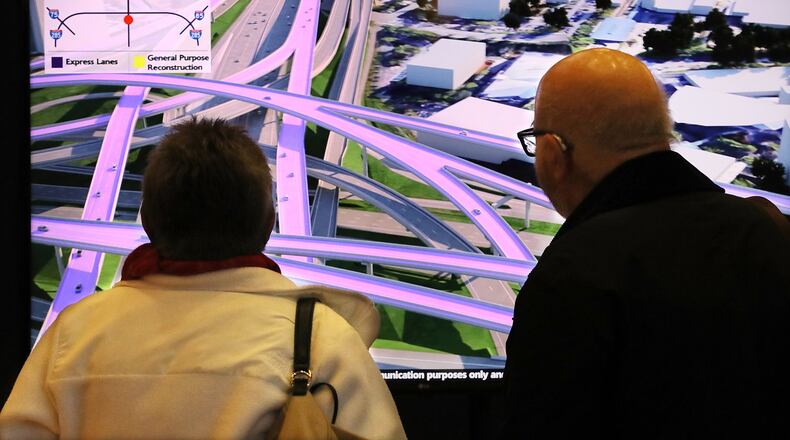 Halina and Constantine Gaurilidis of Sandy Springs watch a visualization of the proposed I-285 Top End Express Lanes during a public meeting Tuesday. The Georgia Department of Transportation is seeking public comment on its latest plans for the toll lanes. Curtis Compton ccompton@ajc.com