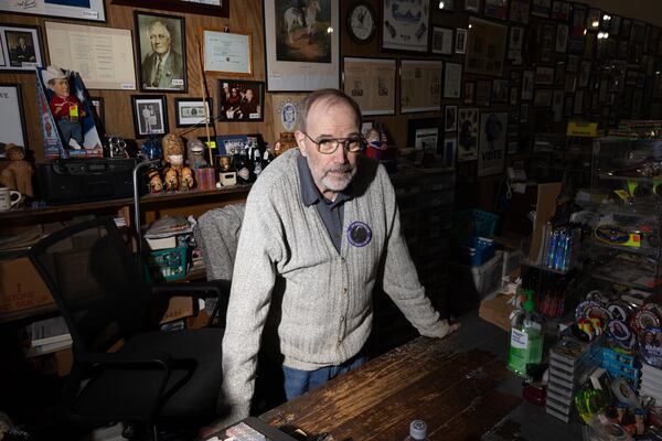 Philip Kurland has sold political campaign memorabilia out of his Plains Trading Post for more than 30 years. Most of what he sells are campaign buttons. All original, dating back to Abraham Lincoln. On Monday, Kurland stood in the middle of his shop, wearing a gray sweater with a big new button attached: “In Memoriam – Jimmy Carter.” (Arvin Temkar / AJC)