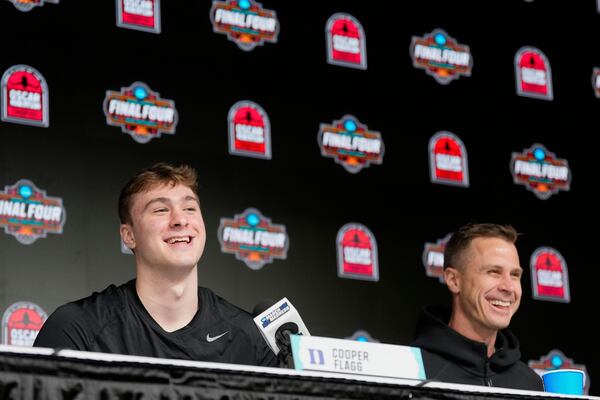 Duke's Cooper Flagg, left, smiles after winning the Oscar Robertson College Player of the Year, awarded by the U.S. Basketball Writers Association, as head coach Jon Scheyer joins him on stage at the Final Four NCAA college basketball tournament Friday, April 4, 2025, in San Antonio. (AP Photo/Eric Gay)