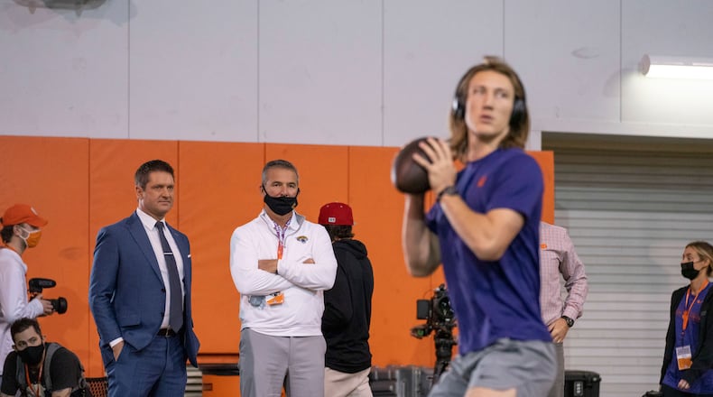 Former Clemson quarterback Trevor Lawrence warming up under the watchful eye of Jacksonville coach Urban Meyer in the background. (Photo courtesy of David Platt/Clemson Athletics)