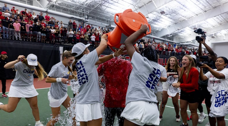 Georgia first-year coach Drake Bernstein (in red) gets a surprise dunking from his players after the Bulldogs won the SEC women's tennis tournament championship inside the Lindsey Hopkins Indoor Tennis Facility with Dan Magill Tennis Complex in Athens, Ga., on Sunday, April 21, 2024. (Conor Dillon/UGA Athletics)