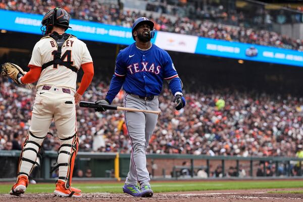Texas Rangers' Adolis García, right, walks past San Francisco Giants catcher Patrick Bailey after striking out during the sixth inning of a baseball game Sunday, April 27, 2025, in San Francisco. (AP Photo/Godofredo A. Vásquez)