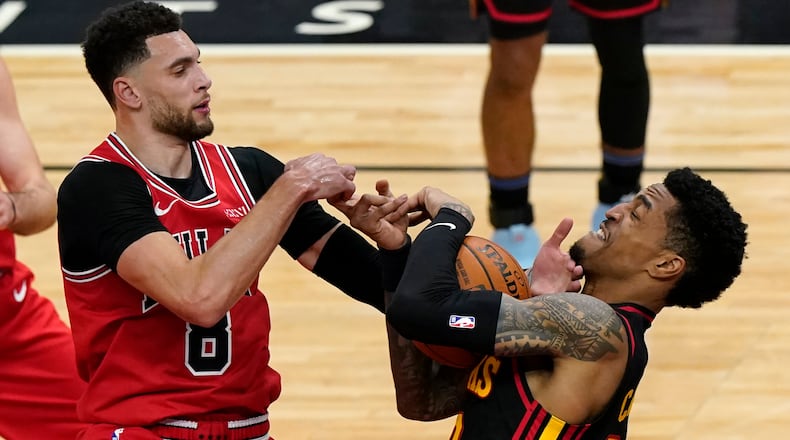 Hawks' John Collins (right) battles for a rebound against Chicago's Zach Lavine during the first half of the season opener against the Bulls Wednesday, Dec. 23, 2020, in Chicago. (Nam Y. Huh/AP)