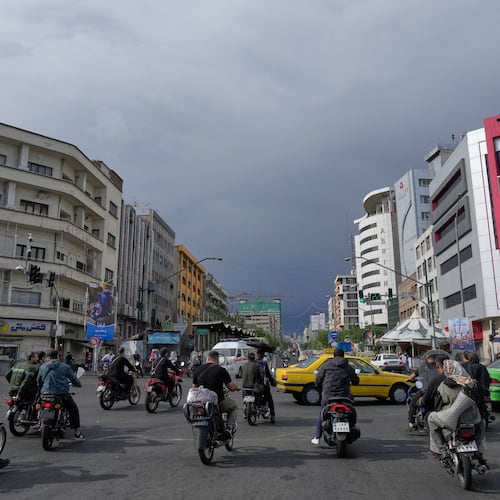 FILE - Motorbikes and cars pass through an intersection in downtown Tehran, Iran, May 17, 2026. (AP Photo/Vahid Salemi, File)
