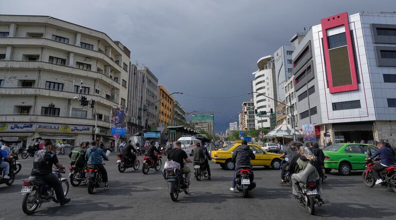 FILE - Motorbikes and cars pass through an intersection in downtown Tehran, Iran, May 17, 2026. (AP Photo/Vahid Salemi, File)