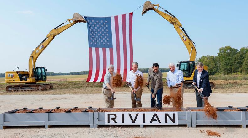 Georgia Gov. Brian Kemp (second from left), Rivian CEO RJ Scaringe (center) and Georgia House Speaker Jon Burns (second from right), along with special guests, participate in the Rivian groundbreaking ceremony on Tuesday, Sept. 16, 2025, in Walton and Morgan counties. (Miguel Martinez/AJC)