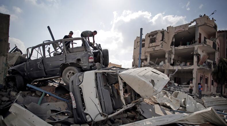 Palestinians search destroyed cars in Rafah's district of Shawkah in the southern Gaza Strip, Tuesday, Aug. 5, 2014. The attack at the Shawkah district east of the Gaza town of Rafah drew what was by far the heaviest shelling by the Israeli military in the Gaza war, killing nearly 100 people that day alone and instantly unraveling a three-day ceasefire shortly after it came into force. (AP Photo/Khalil Hamra) Palestinians search destroyed cars in Rafah's district of Shawkah in the southern Gaza Strip on Tuesday. The attack at the Shawkah district east of the Gaza town of Rafah drew what was by far the heaviest shelling by the Israeli military in the Gaza war, killing nearly 100 people that day alone and instantly unraveling a three-day ceasefire shortly after it came into force. AP/Khalil Hamra