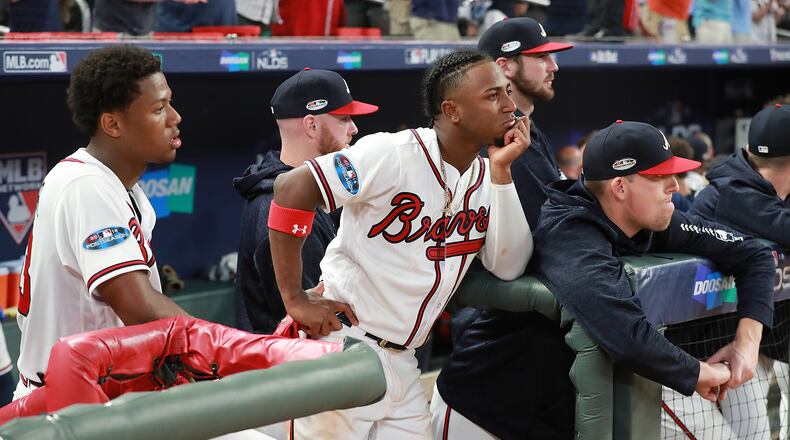Ronald Acuna and Ozzie Albies watch from the dugout as the Dodgers celebrate their 6-2 victory over the Braves Monday at SunTrust Park. (Curtis Compton/ccompton@ajc.com)