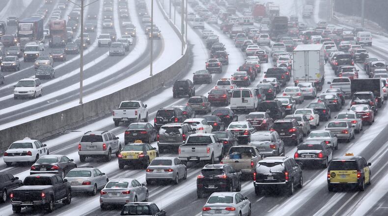 January 28, 2014 Atlanta: Traffic inches along the Connector as snow blankets the Metro on Tuesday afternoon January 28, 2014 as seen from the Pryor Street overpass. BEN GRAY / BGRAY@AJC.COM