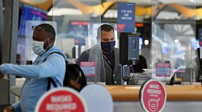 October 5, 2021 Atlanta - A Delta Air Lines employee works in the Domestic Terminal at Hartsfield-Jackson Atlanta International Airport in Atlanta on Tuesday, October 5, 2021. Delta is requiring new hires to be vaccinated. But for existing employees it is instead penalizing unvaccinated workers with a monthly $200 health insurance surcharge starting in November, along with requiring them to take weekly COVID-19 tests and wear masks. (Hyosub Shin / Hyosub.Shin@ajc.com)