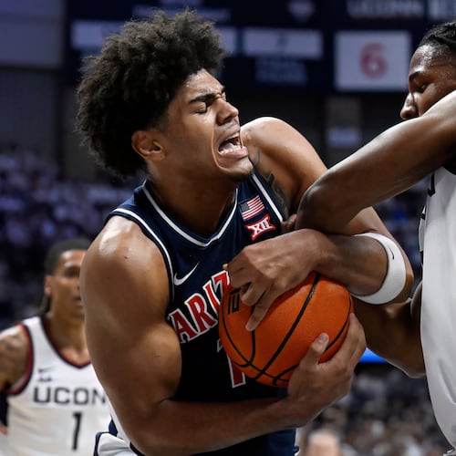 Arizona forward Koa Peat and UConn guard Silas Demary Jr., right, fight for possession of the ball in the first half of an NCAA college basketball game, Wednesday, Nov. 19, 2025, in Storrs, Conn. (AP Photo/Jessica Hill)
